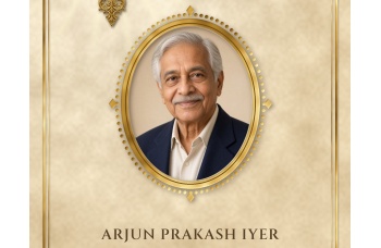 Close-up of the Tan cover: a portrait of a smiling older man with grey hair in a navy jacket, filling a beaded gold oval frame with diamond points, above his name in dark brown capitals on a parchment background.
